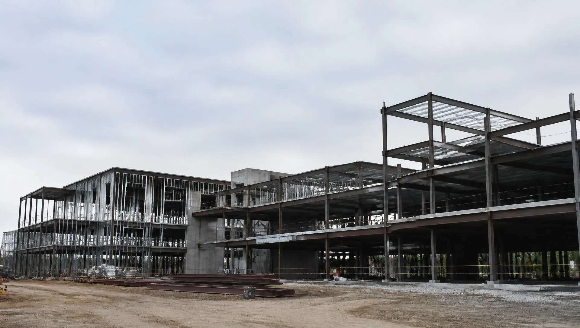 Steel and concrete frame of a commercial building partway through construction on an overcast morning